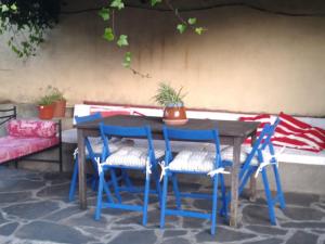 una mesa de madera con sillas azules y un sofá en Casa Rural El Fortin, en Gata