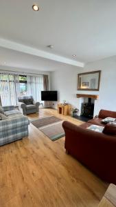 a large living room with a couch and a television at McCareys Loanen Holiday Home in Larne