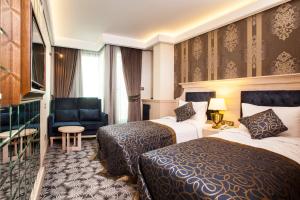 Pokój hotelowy z 2 łóżkami i krzesłem w obiekcie The Conforium Hotel İstanbul w Stambule