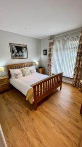 a bedroom with a large bed and a wooden floor at McCareys Loanen Holiday Home in Larne