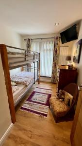 a bedroom with a bunk bed and a chair at McCareys Loanen Holiday Home in Larne