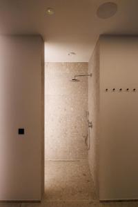 a bathroom with a shower with a stone wall at Holiday Home L'O Reine - with luxury wellness in Sint-Pieters-Leeuw