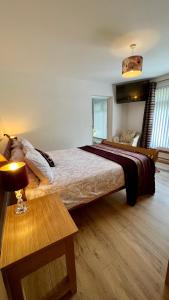 a bedroom with a large bed and a table at McCareys Loanen Holiday Home in Larne
