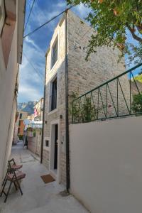 un edificio con una pared blanca y una valla en Romantic stone house/City center/Beach!, en Makarska