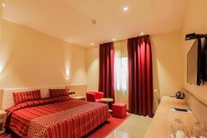 a hotel room with a bed and red curtains at Heliconia Park Port Harcourt Hotel and Suites in Port Harcourt