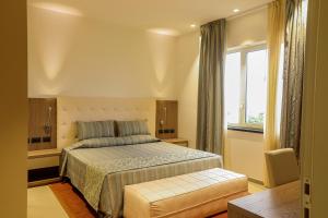 a hotel room with a bed and a window at Heliconia Park Port Harcourt Hotel and Suites in Port Harcourt