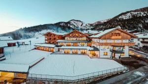a large building with snow on the ground at Tillga Glück - 4 stars in Obertilliach