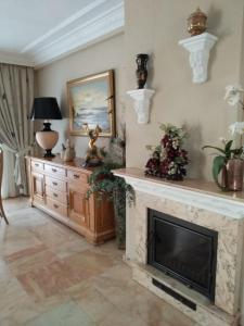 a living room with a fireplace and a television at Casa adosada - Los Boliches - Fuengirola in Fuengirola