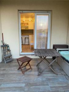 a patio with a bench and a table and a window at Joli appartement proche océan et centre ville in Lacanau