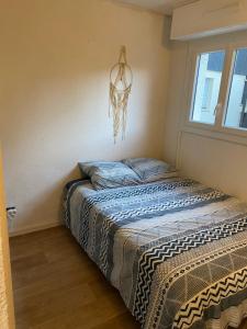 uma cama num quarto com um lustre em Joli appartement proche océan et centre ville em Lacanau