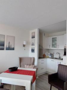 ein Wohnzimmer mit einem Tisch und einer Küche in der Unterkunft Loreley Lounge II in Patersberg