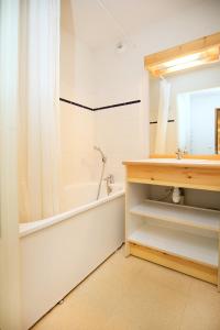 łazienka z wanną, umywalką i lustrem w obiekcie Les Balcons PROCHE PARC NATIONAL VANOISE appartements 2 pieces 6 pers MONTAGNE ALP w mieście Termignon