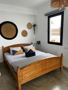 un letto in legno in una camera con finestra di Casa Nusa a La Santa