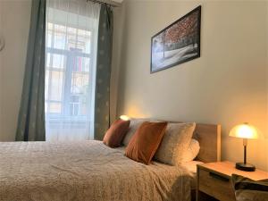 a bedroom with a bed and a window at Glorious Apartment Near The Old City in Lviv