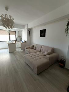 a living room with a couch and a kitchen at Apartment By The Lake with a View in Mamaia