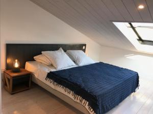 Un dormitorio con una cama con un edredón azul. en Duplex vue sur tour Appartement Remparts 3, en La Rochelle