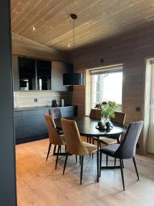 cocina y comedor con mesa y sillas en Panorama 15 - Beautiful mountain view, en Sogndal