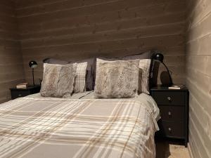 1 dormitorio con 1 cama con 2 mesitas de noche y 2 lámparas en Panorama 15 - Beautiful mountain view, en Sogndal