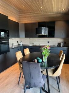una cocina con mesa negra y sillas en Panorama 15 - Beautiful mountain view en Sogndal