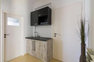 a small kitchen with a sink and a door at Minimal Apartment In Athens in Athens