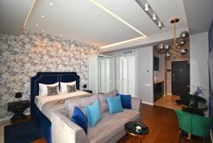 a bedroom with a bed and a couch with blue pillows at Yerevan4you NEW Studio Apartment in Yerevan