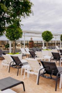 un groupe de chaises et de tables sur un toit dans l'établissement Hotel France, à Vinnytsia