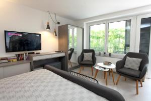 a bedroom with a bed and two chairs and a tv at Modern Apartment Parenzana IZMA in Portorož