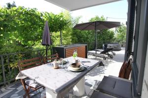 a table and chairs on a patio with an umbrella at Modern Apartment Parenzana IZMA in Portorož