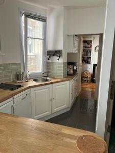 a kitchen with white cabinets and a sink and a window at Charming 2 bedrooms flat near Trocadéro in Paris