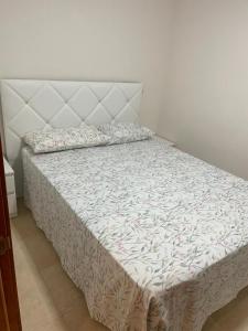 Schlafzimmer mit einem Bett mit einem weißen Kopfteil in der Unterkunft Casa Primi in La Nucía