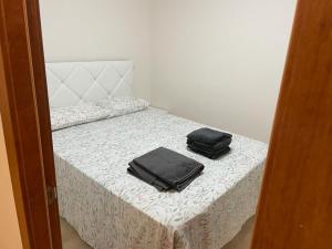 ein Bett mit zwei schwarzen Säcken darüber in der Unterkunft Casa Primi in La Nucía