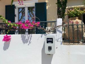 a white mail box on a white wall with flowers at Casa Buganvilla in Minia