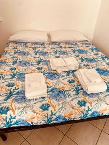 Una cama con toallas y toallas encima. en casa di Golfo Aranci mare en Golfo Aranci