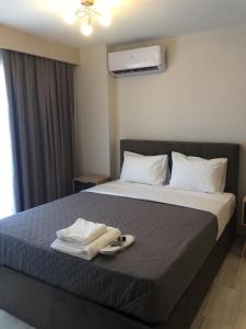 a hotel room with a bed with two towels on it at THOMAS STUDIOS & APARTMENTS PARALIA in Paralia Katerinis