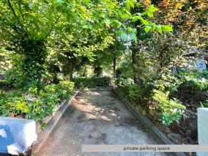 a path in a garden with trees and bushes at #Villa Niovi by halu! Sani Villas in Sani Beach