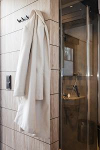 a white coat hanging on a wall in a bathroom at Roatel Staufenberg-Lutterberg A7 my-roatel-com in Staufenberg