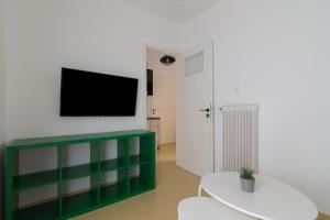 a living room with a tv on a wall at Minimal Apartment In Athens in Athens