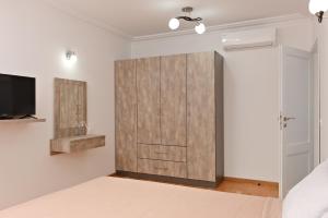 ein Schlafzimmer mit einer Schiebetür zur Scheune und einem TV in der Unterkunft Апартамент за гости Дарива in Smoljan