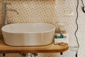 La salle de bains est pourvue d'une baignoire blanche assise sur une table en bois. dans l'établissement Hotel Jumeaux, à Breuil-Cervinia