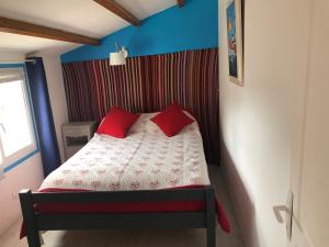 レ・サ​​ーブル・ドロンヌにあるOlékatéのベッドルーム1室(赤い枕2つ付きのベッド1台付)