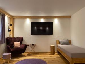a room with a bed and a tv on the wall at Neurenovierte Ferienwohnung Xaver in Holzkirchen