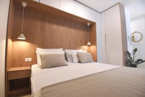sypialnia z dużym łóżkiem z białą pościelą i poduszkami w obiekcie Consul Apartment - Zadar city center w mieście Zadar