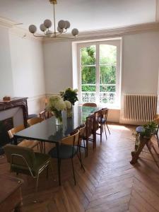 a dining room with a table and chairs and a window at La Villégiature in Coutances