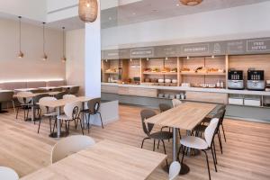 a restaurant with tables and chairs and a bakery at B&B HOTEL Barcelona Mataro in Mataró