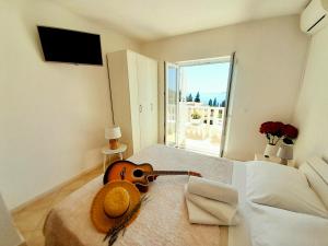 um violino sentado numa cama num quarto em Rooms Villa Gala em Mlini