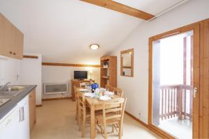 a kitchen with a table with chairs and a window at Les Balcons PROCHE PARC NATIONAL VANOISE appartements 2 pieces 6 pers MONTAGNE in Termignon