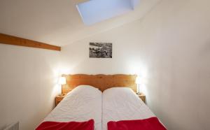 een slaapkamer met een bed met twee lampen op twee tafels bij Les Balcons PROCHE PARC NATIONAL VANOISE appartements 2 pieces 6 pers MONTAGNE in Termignon
