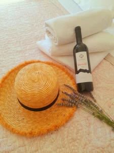 uma garrafa de vinho ao lado de um chapéu e um batedor em Rooms Villa Gala em Mlini