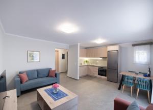 a living room with a blue couch and a kitchen at Fragiato Apartment in Lefkada
