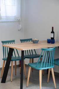 a wooden table with two blue chairs around it at Fragiato Apartment in Lefkada Town